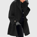 Black tailored coat with tonal trim, oversized collar framing the neckline, worn open