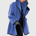 Blue shawl collar coat with black piping, mid-thigh length and button-through cuff detail