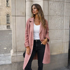 Woman wearing a longline dusty pink wool coat with wide lapels over a white top and black jeans