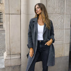 Side view of a mid grey longline wool coat with notch lapels and turned-back cuffs, worn open