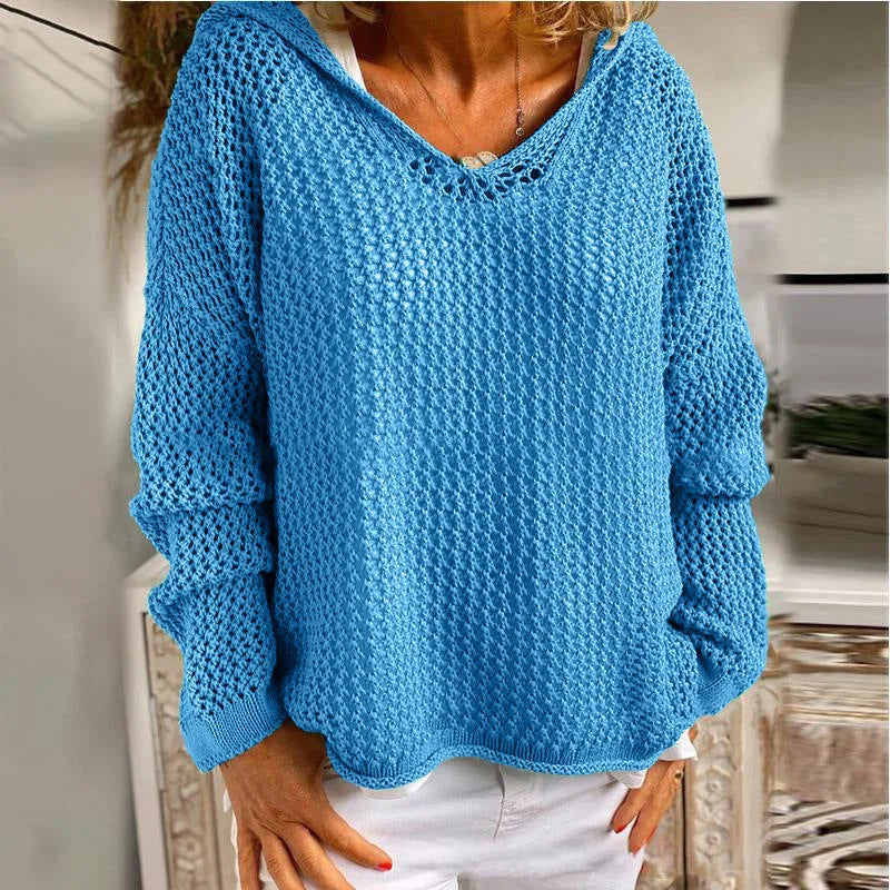 Product shot of the yellow open-knit hooded jumper on a model, front view with hands on hips