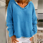 Product shot of the yellow open-knit hooded jumper on a model, front view with hands on hips