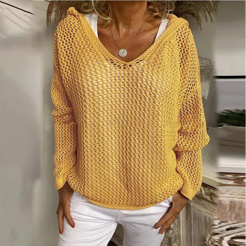 Product shot of the red open-knit hooded jumper on a model, front view showing batwing sleeves