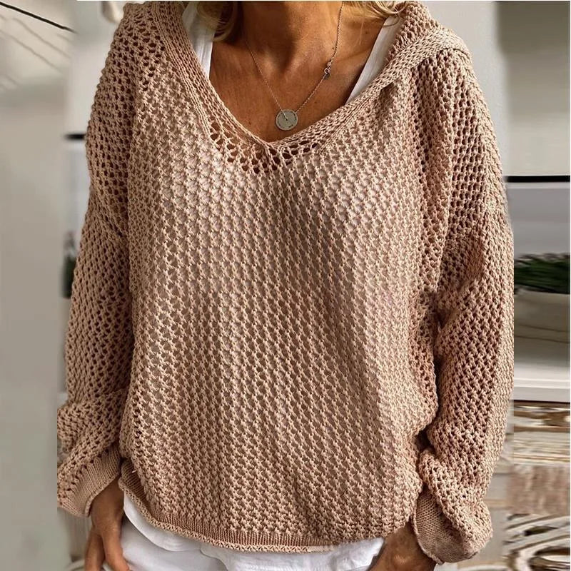 Product shot of the green open-knit hooded jumper on a model, front view against a neutral wall
