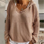 Product shot of the green open-knit hooded jumper on a model, front view against a neutral wall