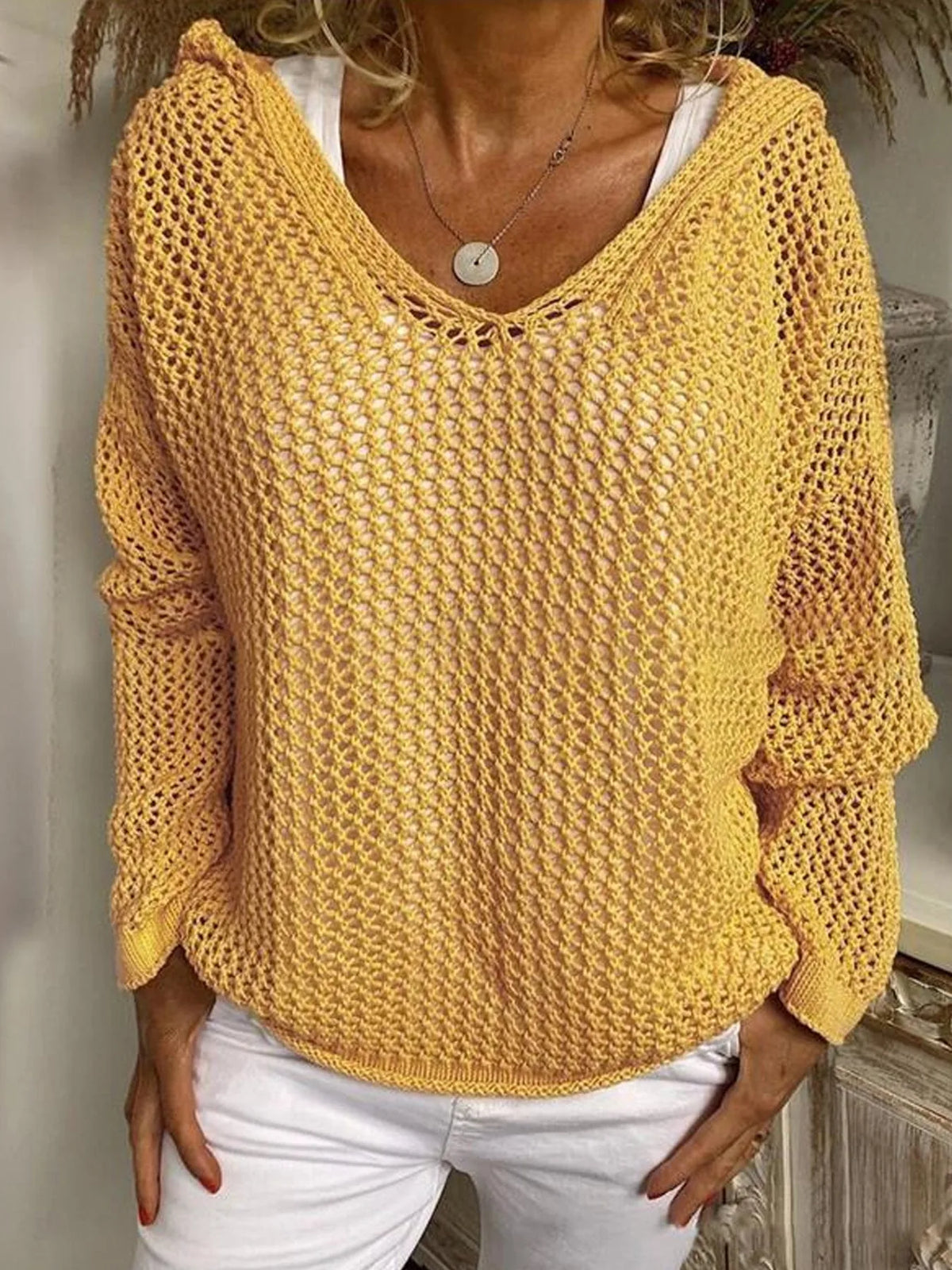 Model wears the yellow open-knit hooded jumper over a white top, front view showing relaxed fit