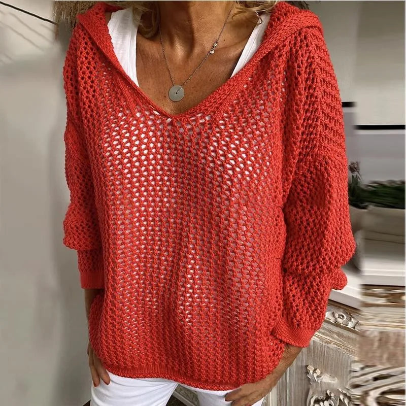 Model wears the red open-knit hooded jumper, front view showing long sleeves and relaxed silhouette
