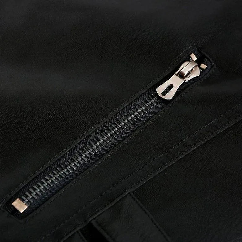 Macro detail of a metal zip pocket fastener on the black leather jacket