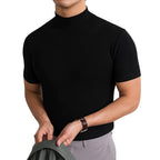 Front angle of a man in a black fitted mock-neck short-sleeve top, shown holding a jacket over his arm.