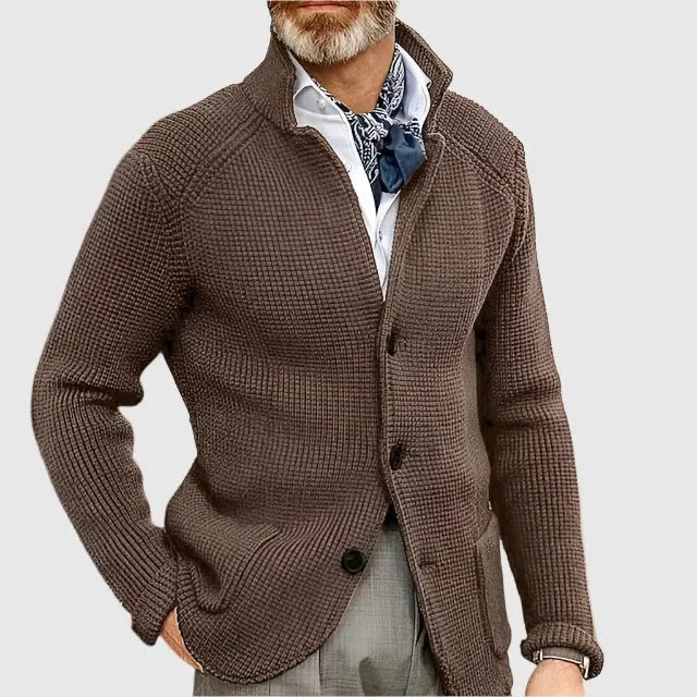 Man wearing the olive green cardigan outdoors with grey trousers and a wristwatch