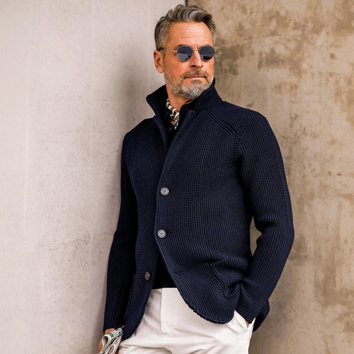 Man adjusting the collar of the navy textured knit cardigan, close-up front view