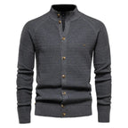 Charcoal grey textured knit cardigan with stand collar, horn-style buttons and small metal logo badge