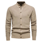 Beige knit cardigan with stand collar, raglan sleeves and brass-tone buttons, front view