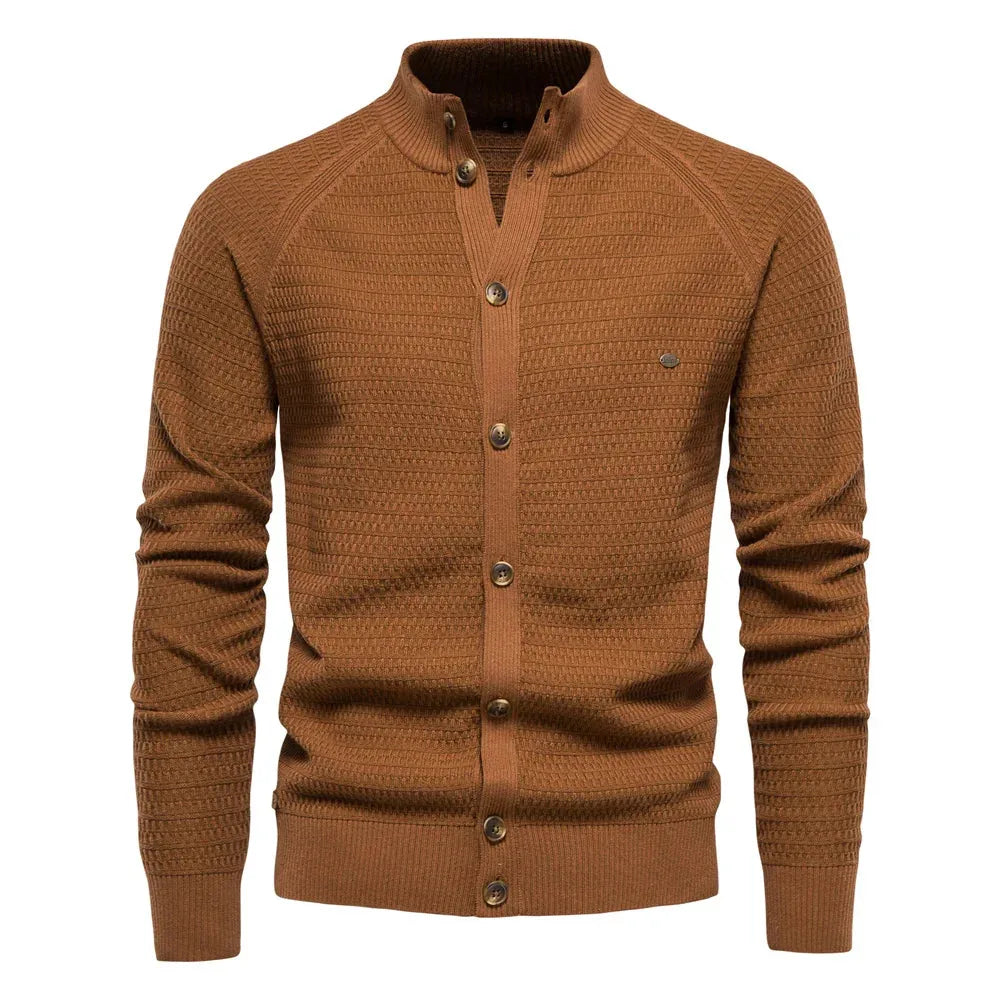 Brown textured cardigan with stand collar, button placket and subtle metal badge on the chest