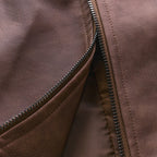 Close-up of open zip fastener showing brown leather exterior and soft inner lining