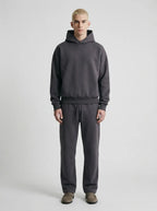 Close front view of the brown tracksuit highlighting the dropped shoulder seam and ribbed hem detailing