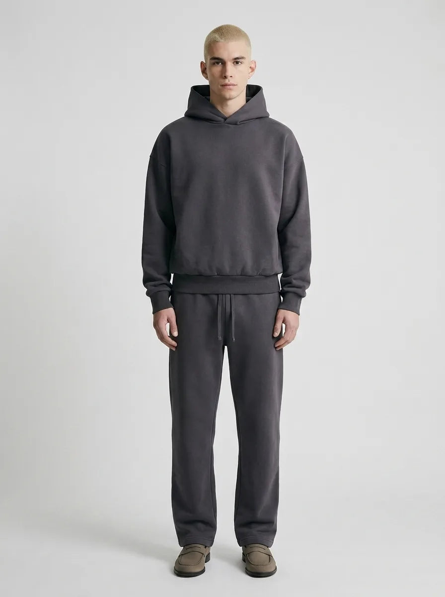 Close front view of the brown tracksuit highlighting the dropped shoulder seam and ribbed hem detailing