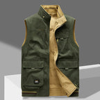 Olive green multi-pocket gilet laid flat on a grey backdrop, zip undone to reveal a mustard quilted lining