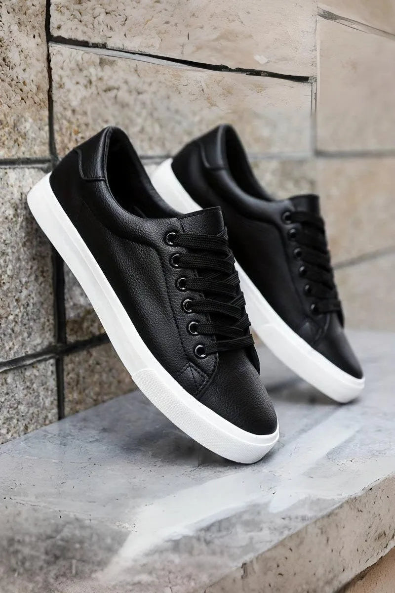 Close-up top-down view showing the lacing and stitched panels of a white trainer