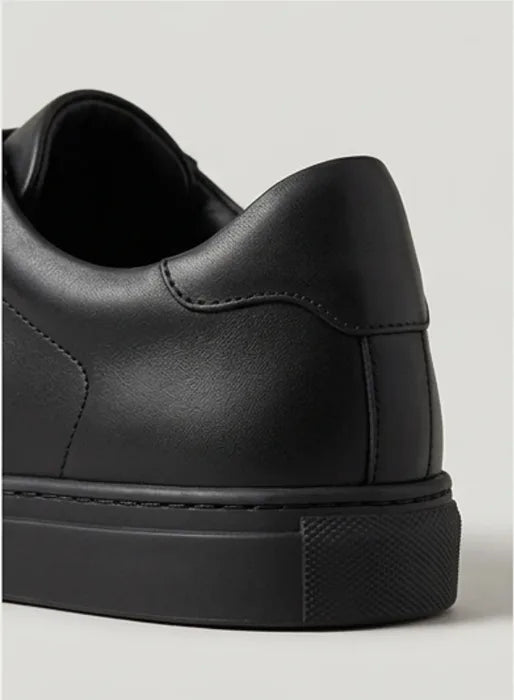 Close-up of the padded heel and textured outsole on a black trainer