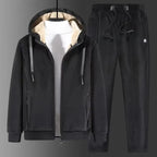 Black fleece tracksuit with hood up over a white jumper, shown on a hanger with matching joggers
