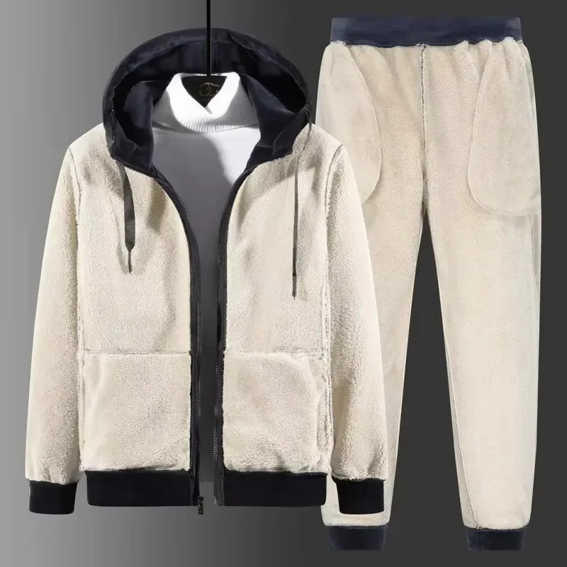 Cream sherpa fleece tracksuit with navy trims, hood up over a white jumper, hung against a grey backdrop
