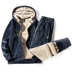 Navy blue velour hooded jacket and joggers laid flat, unzipped to show the cream fleece lining
