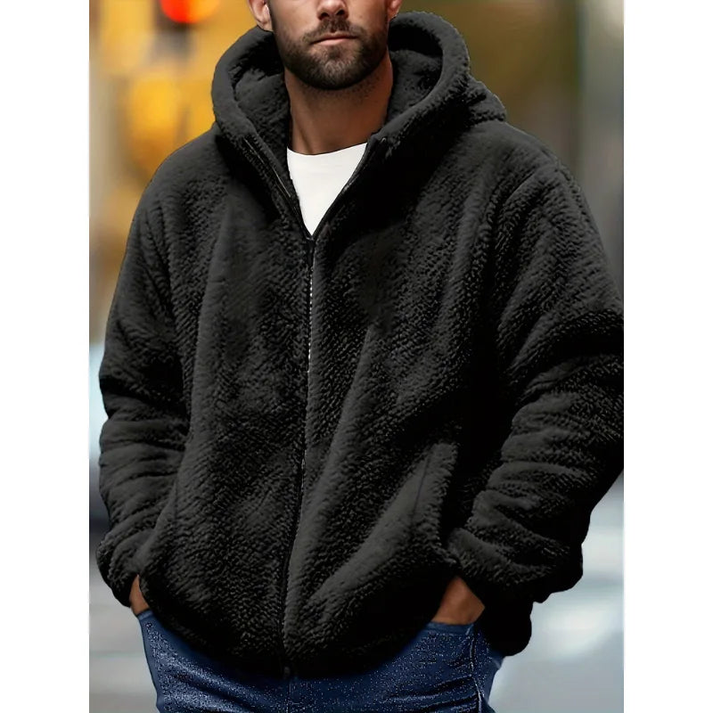 Man wearing a black fluffy fleece zip-up hoodie with the hood up, styled with dark jeans and a white t-shirt underneath