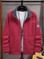 Burgundy red fleece jacket on a hanger over a white t-shirt, showing the collar and sleeve patch