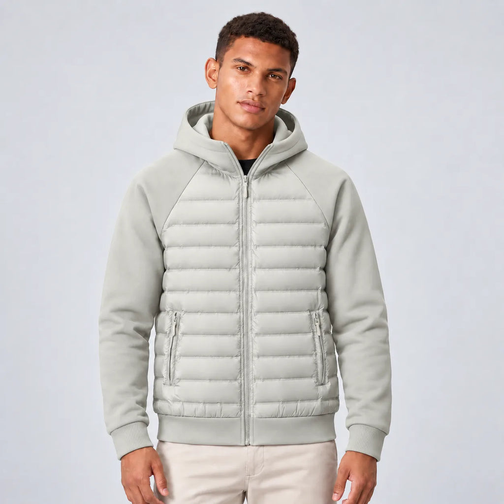 Front view of man wearing the hooded puffer jacket in light grey with quilted panels