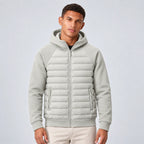Front view of man wearing the hooded puffer jacket in light grey with quilted panels