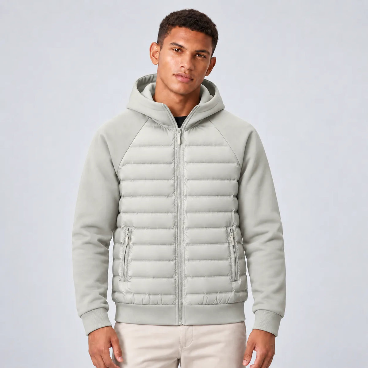 Front view of man wearing the hooded puffer jacket in light grey with quilted panels