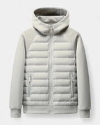 Light grey hooded puffer jacket laid flat, showing quilted front panel, zip pockets and softshell raglan sleeves