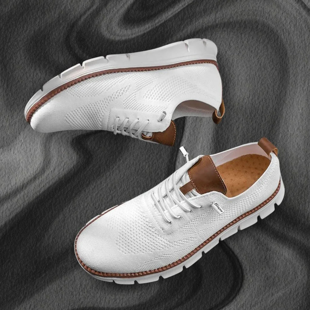Pair of white knit lace-up trainers shown from above and the side on a grey fabric backdrop