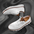 Pair of white knit lace-up trainers shown from above and the side on a grey fabric backdrop