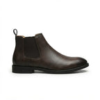Side profile of a dark brown leather Chelsea boot with elastic side panel and pull tab, round toe and stacked sole