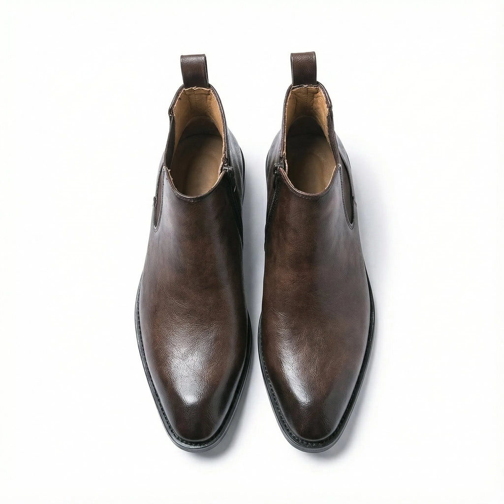 Top-down view of a pair of dark brown leather Chelsea boots showing pull tabs and almond-shaped toes