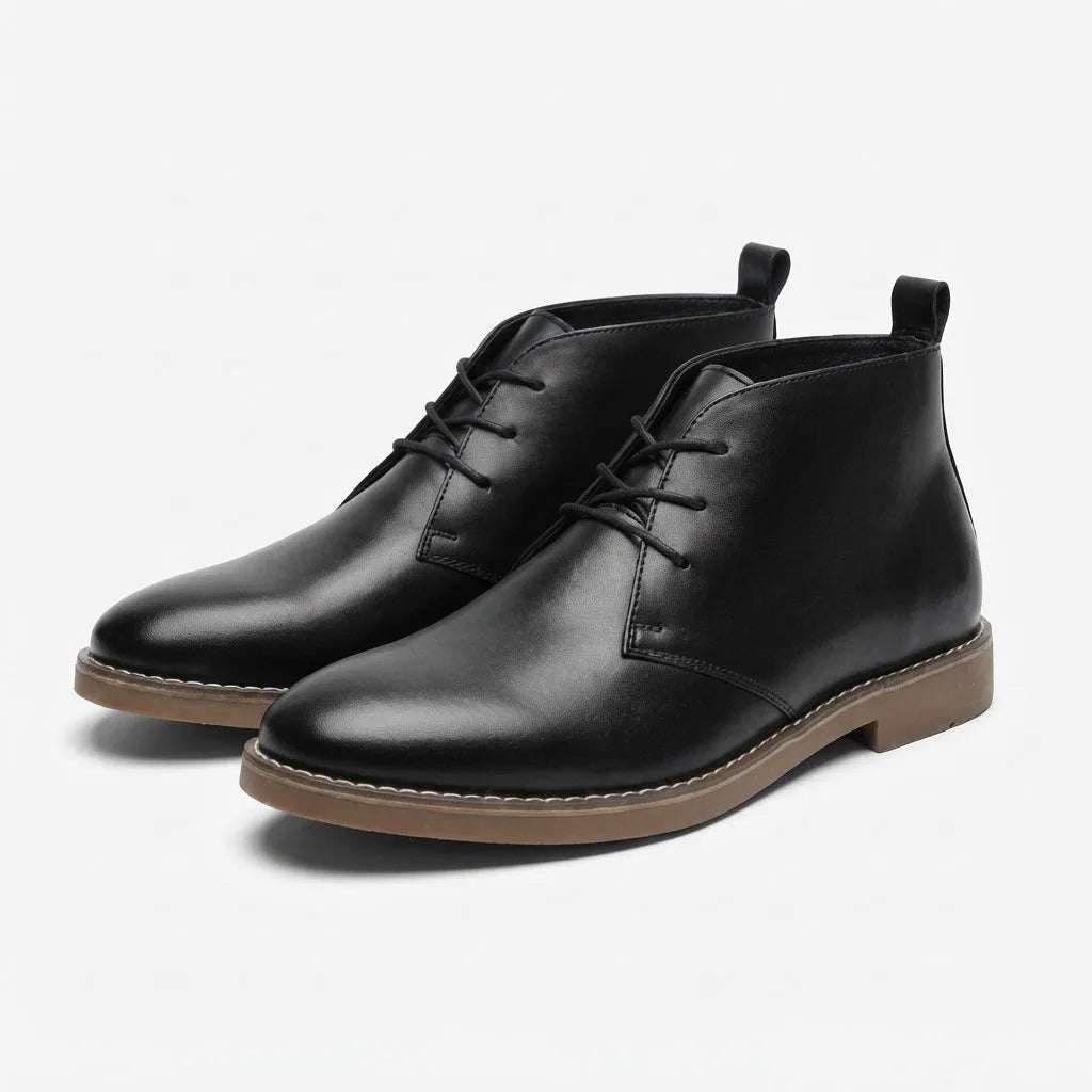 Pair of black leather lace-up desert boots shown at an angle on a plain background