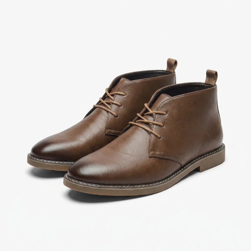 Pair of brown leather desert boots with gum sole and tonal laces, angled view