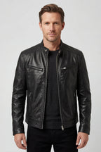 Front view of a man wearing a black leather biker jacket with silver zip fastening over a dark jumper