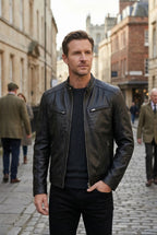 Man wearing the black leather jacket open over a jumper while walking on a cobbled city street