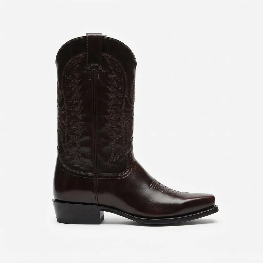 Side profile of a dark brown leather cowboy boot with stitched shaft and stacked block heel against a plain background