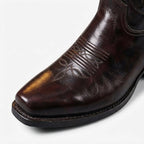 Close-up of the brown leather boot toe highlighting the polished finish, decorative stitching and ridged sole edge