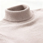 Close-up of the ribbed polo neck collar in light beige knit, showing fine knit texture