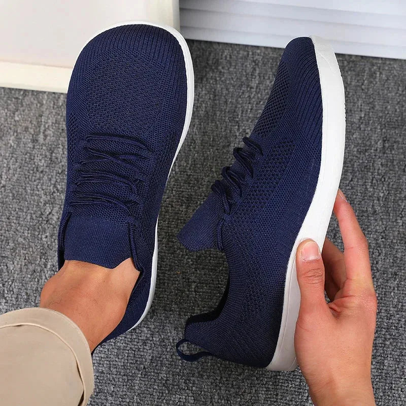 Close-up of the heel pull tab and ankle collar on a light blue knit trainer