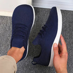 Close-up of the heel pull tab and ankle collar on a light blue knit trainer
