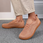 Rear angle view of light blue knit trainers showing the heel seam and sole thickness