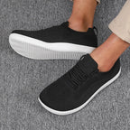 Top-down angle of black knit trainers showing breathable mesh texture and white contrast sole
