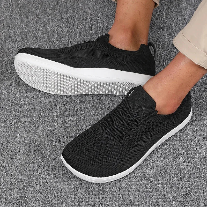 Top-down angle of black knit trainers showing breathable mesh texture and white contrast sole