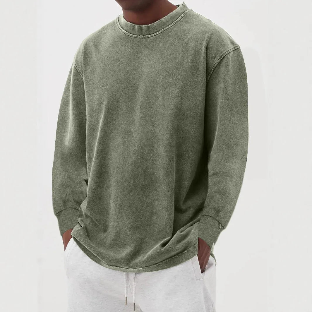 Olive green oversized jumper with long sleeves and visible seam detailing on the shoulder